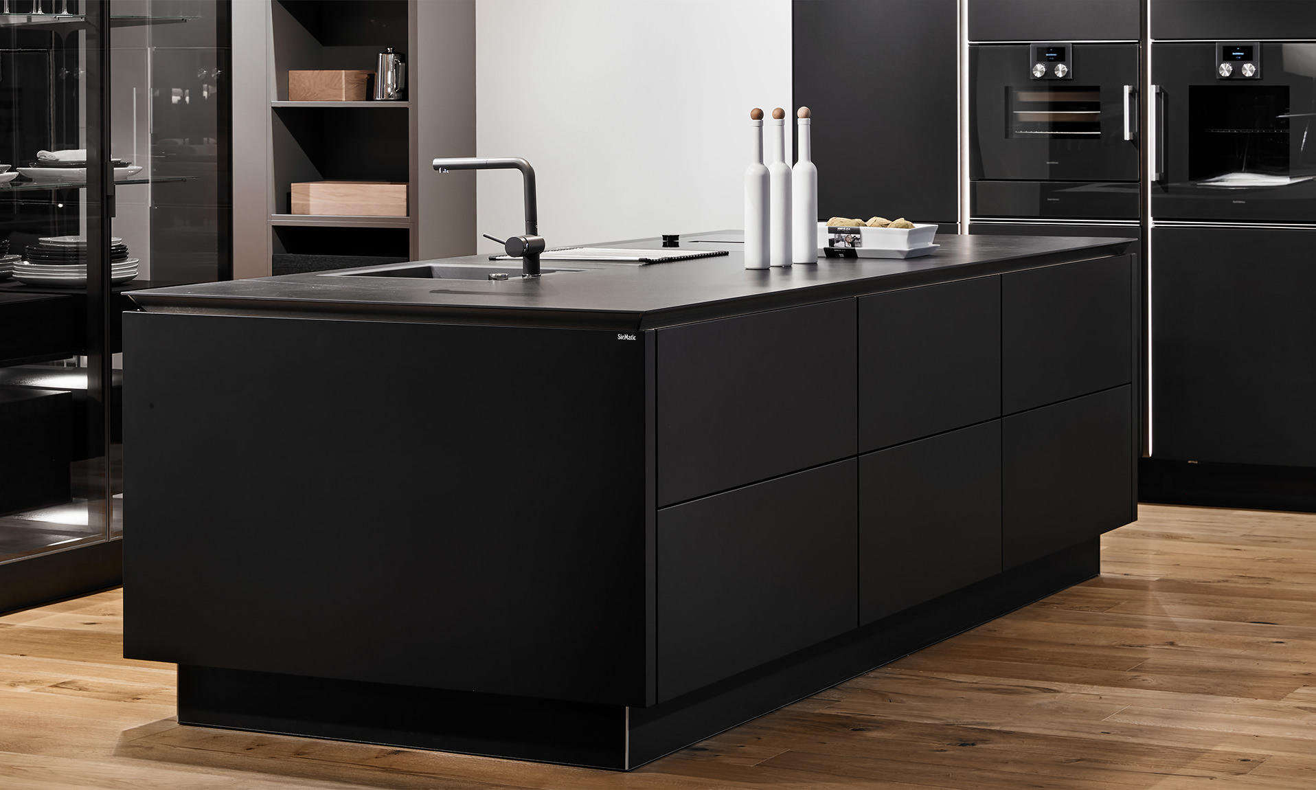 Küchen von Bühler Einrichtungen mattblaue Kücheneinrichtung mit warmen Holzelementen, Kochinsel und Theke