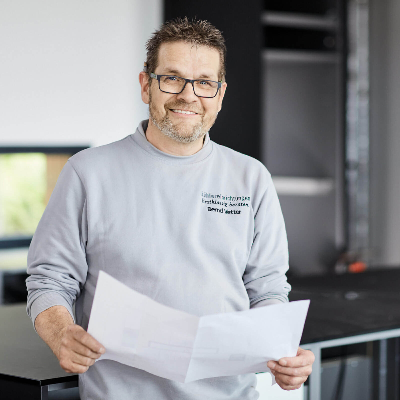 Portrait Bernd Vetter mit Plan in der Hand - individuelle Einrichtung, Möbelanpassung, 3D-Planung, Küchenanpassung, Service, Möbel nach Maß - bühler einrichtungen in Friesenheim bei Offenburg zwischen Karlsruhe und Freiburg